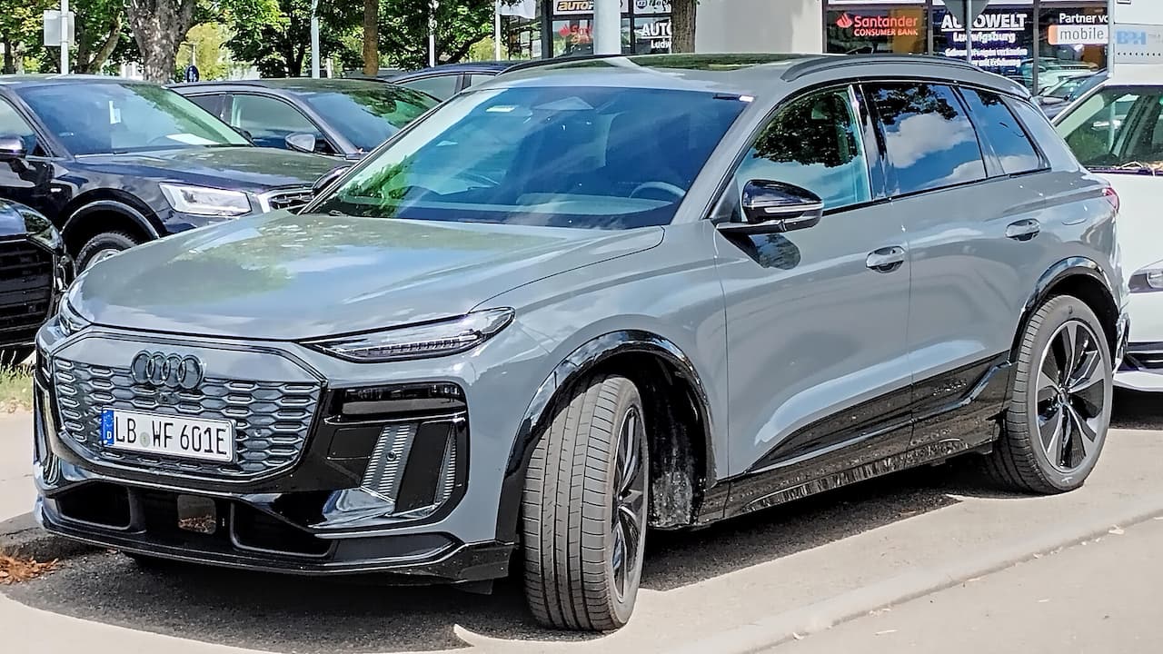 Silver Audi SQ6 e-tron electric SUV with distinctive grille and sporty styling parked on urban street