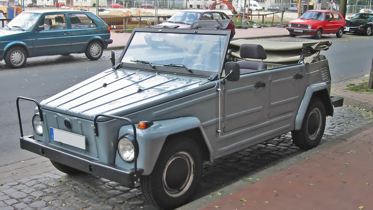 Gray Volkswagen Thing (Type 181) parked on cobblestone street with other cars visible in background