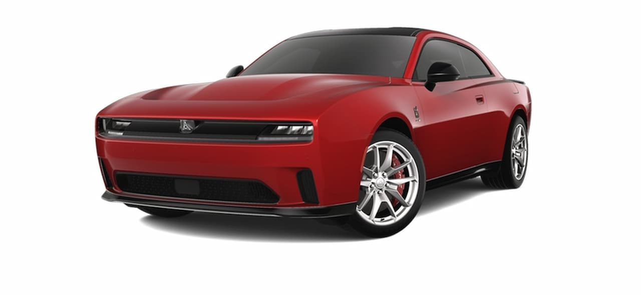 Red 2025 Dodge Charger R/T Scat Pack muscle car with black roof and chrome wheels on white background