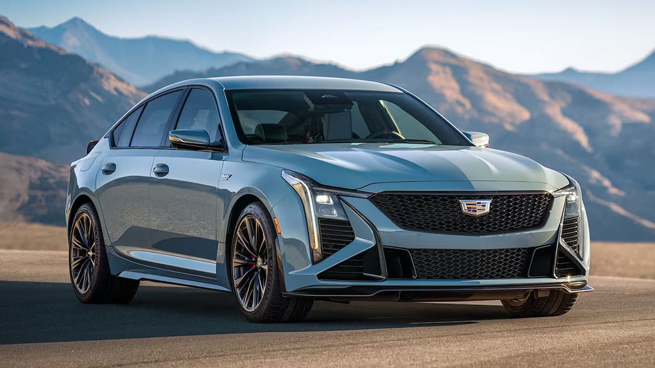 Silver 2025 Cadillac CT5-V Blackwing parked on desert road with dramatic mountain landscape in background under clear sky