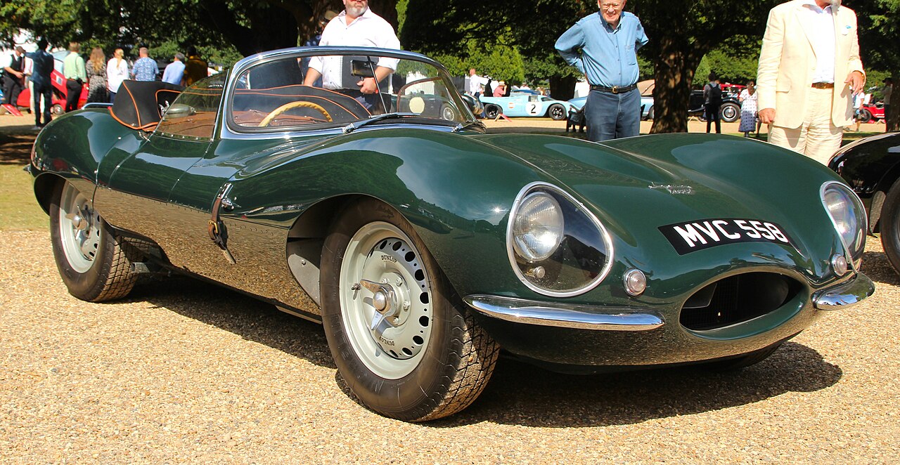 Green 1957 Jaguar XKSS classic sports car with license plate "NYC 550" displayed at outdoor car show event