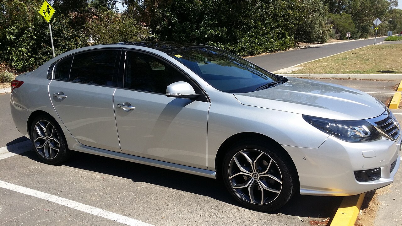 Silver sedan with dark tinted windows parked on street, featuring alloy wheels and modern styling in residential area