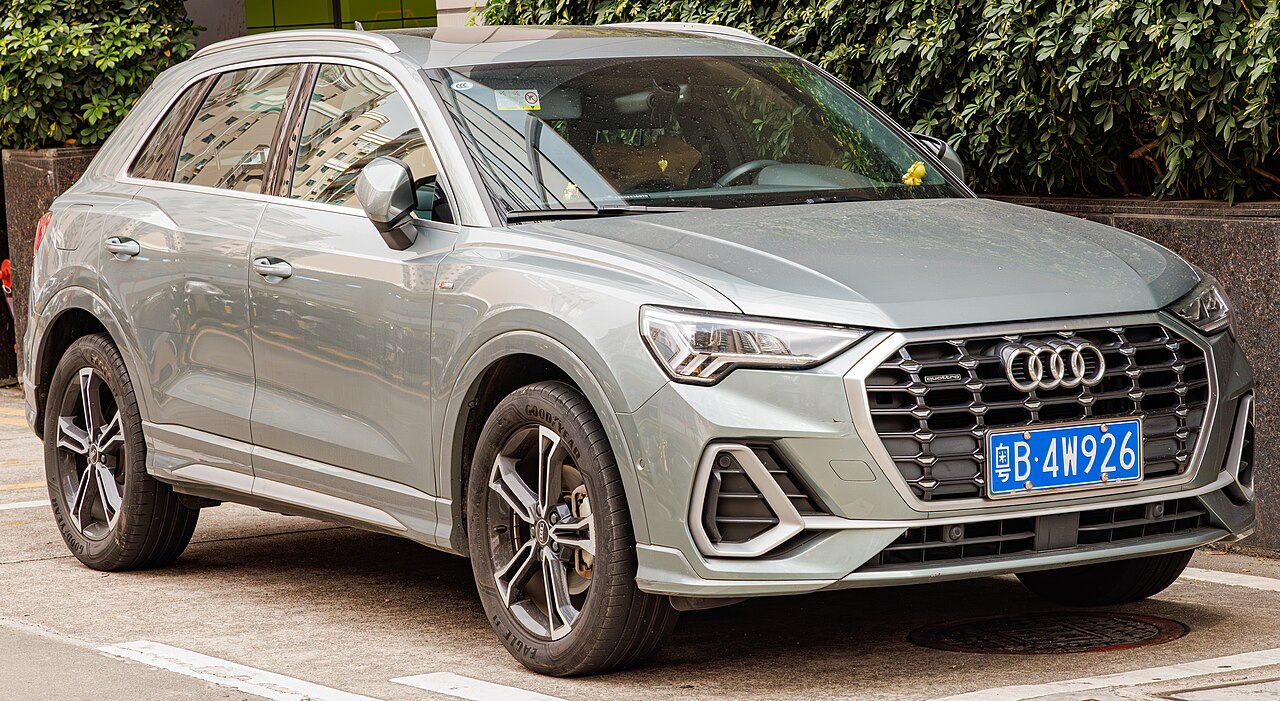 Silver 2025 Audi Q3 SUV parked on street with distinctive grille, LED headlights, and blue license plate