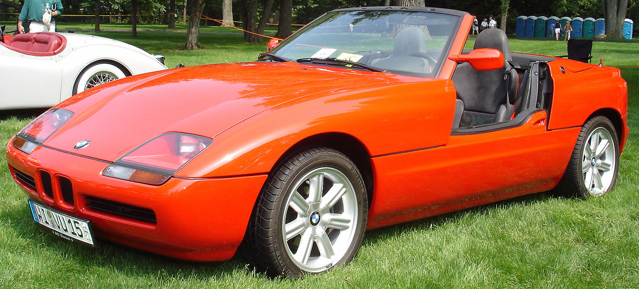 Bright orange 1989 BMW Z1 with retractable doors and distinctive styling at outdoor car show