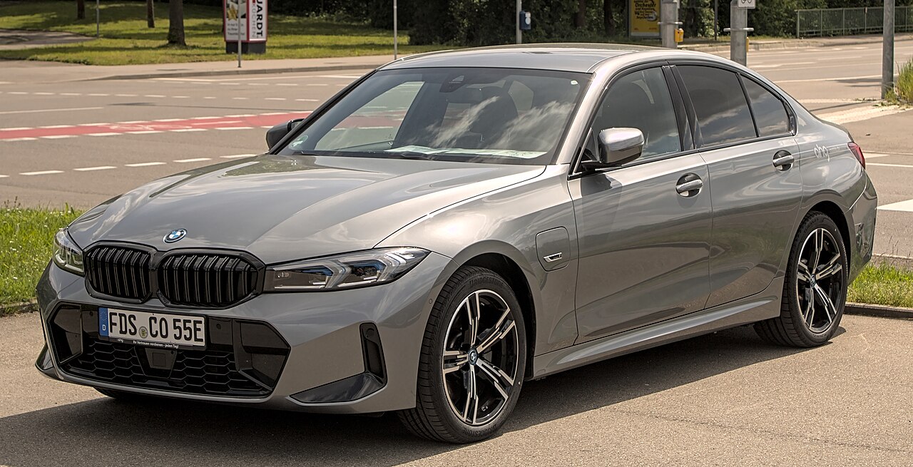 Silver BMW 3 Series sedan parked on a street, featuring black grille, sporty wheels, tinted windows, and sleek, modern design