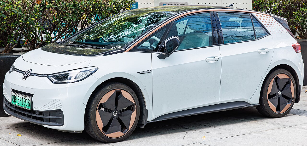 White 2025 Volkswagen ID.3 electric hatchback parked on street with distinctive copper-colored wheel accents and green license plate