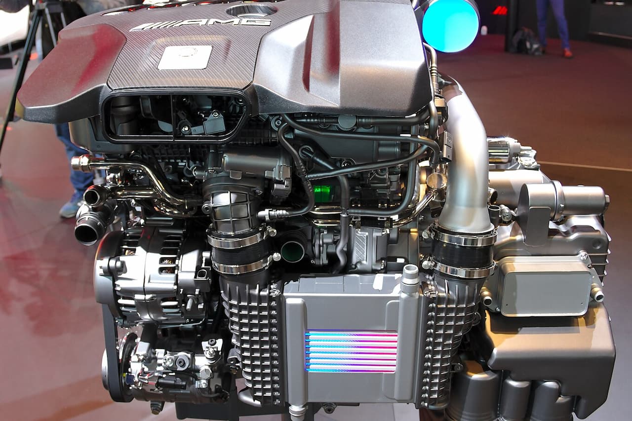 Mercedes-AMG M139 turbocharged engine display showing complex internal components, intercooler, turbocharger, and AMG branding on engine cover