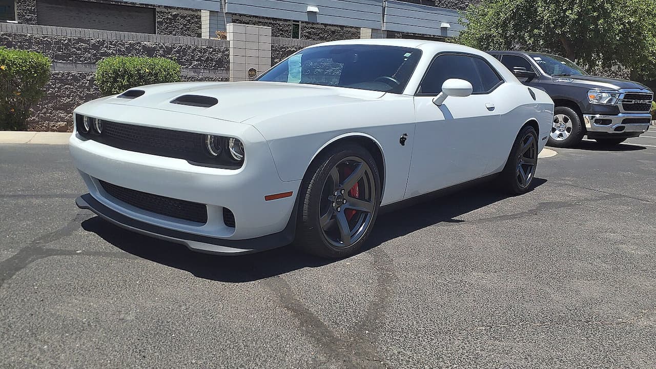 White Dodge Challenger SRT Hellcat Redeye with hood scoops, red brake calipers, and black wheels 