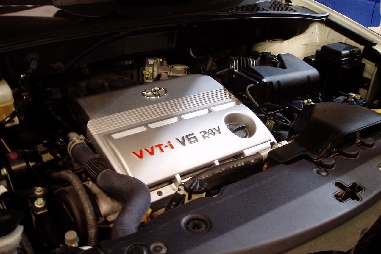 Toyota 1MZ-FE engine bay showing VVT-i V6 24V engine with silver valve cover, air intake box, and various engine components under hood
