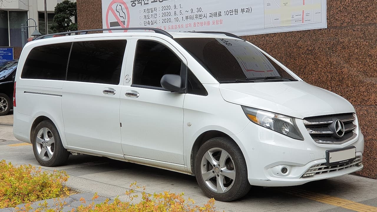 White 2021 Mercedes-Benz Metris van with tinted windows parked in front of building with Korean signage