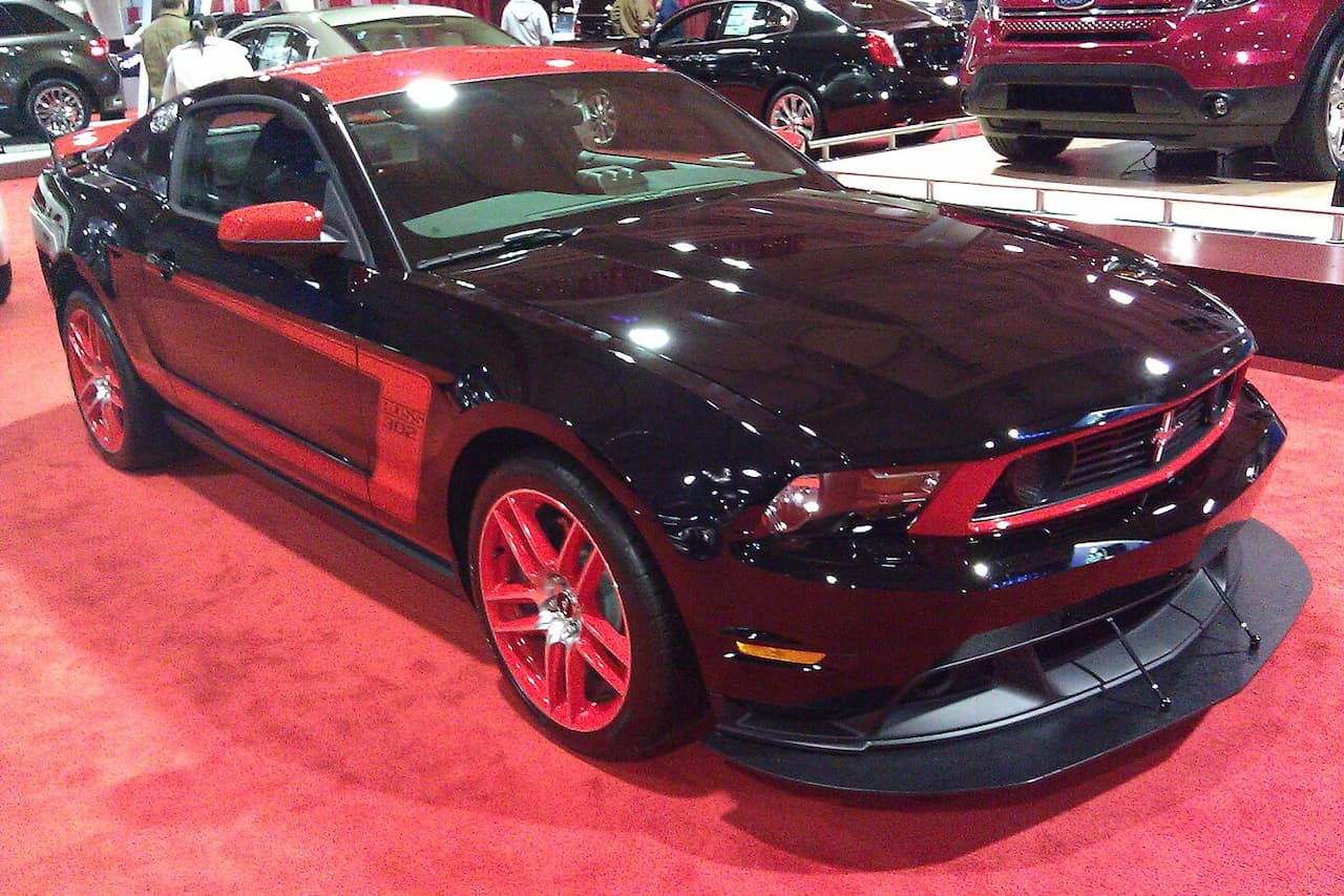 Black Ford Mustang Boss 302 Laguna Seca with red accents and wheels displayed at auto show