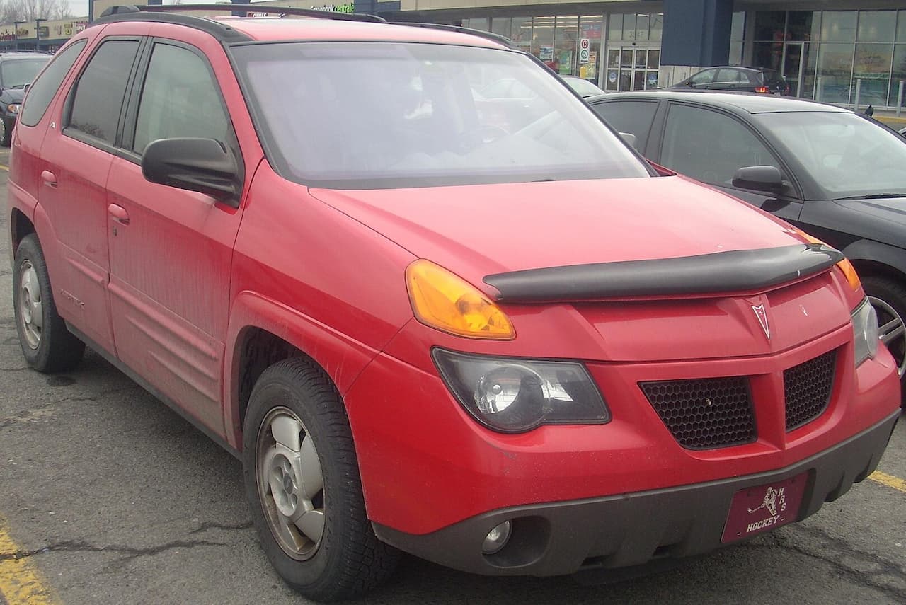 Red 2001 Pontiac Aztek with distinctive angular design parked in lot with other vehicles