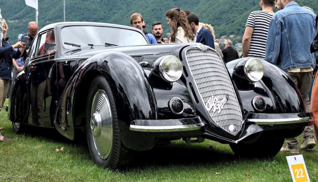 Black Alfa Romeo 8C 2900B classic car with distinctive grille and flowing fenders displayed at outdoor concours event