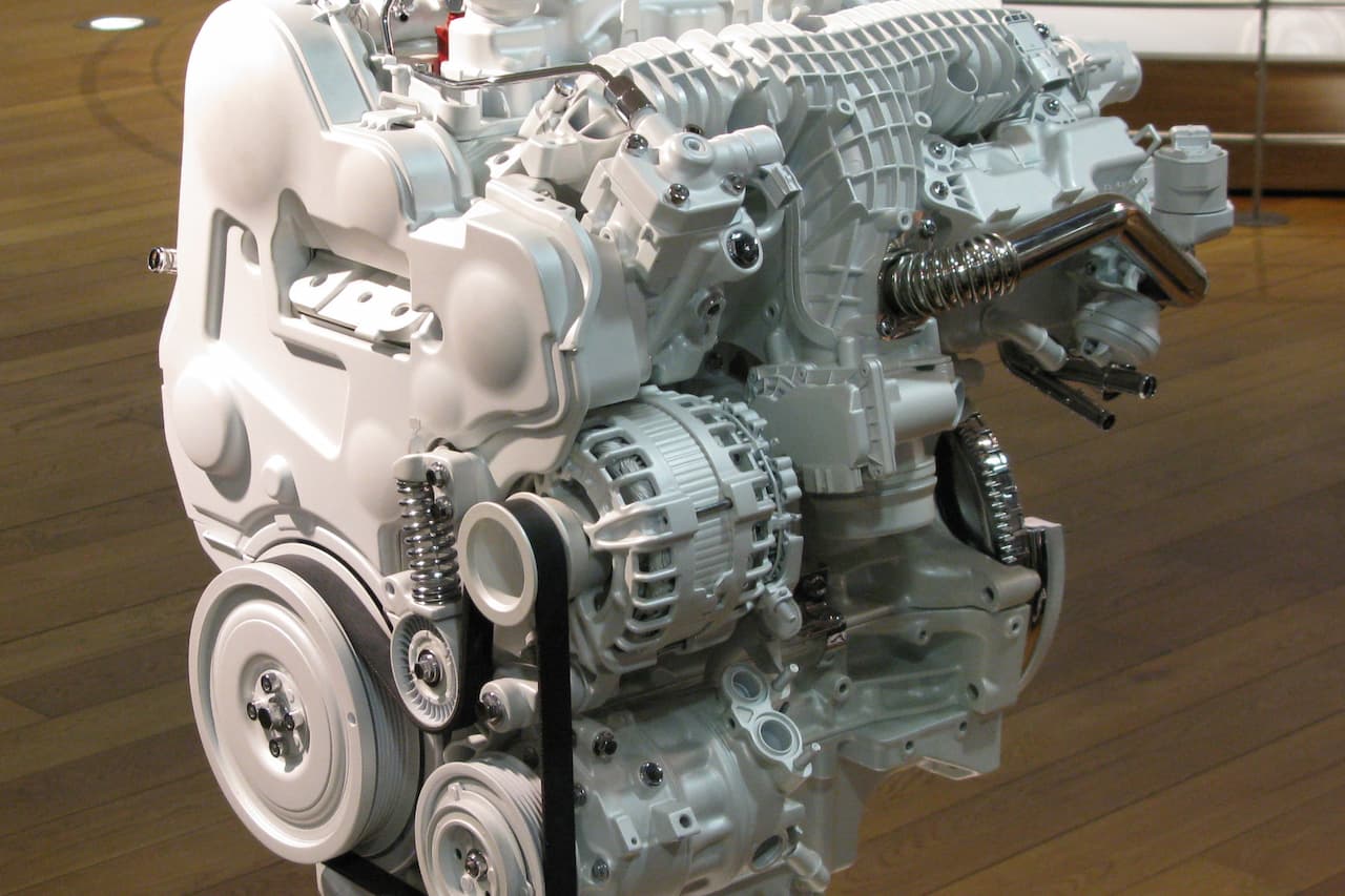 Volvo T8 Twin Engine display showing supercharged engine block, alternator, pulleys, and integrated electric motor components