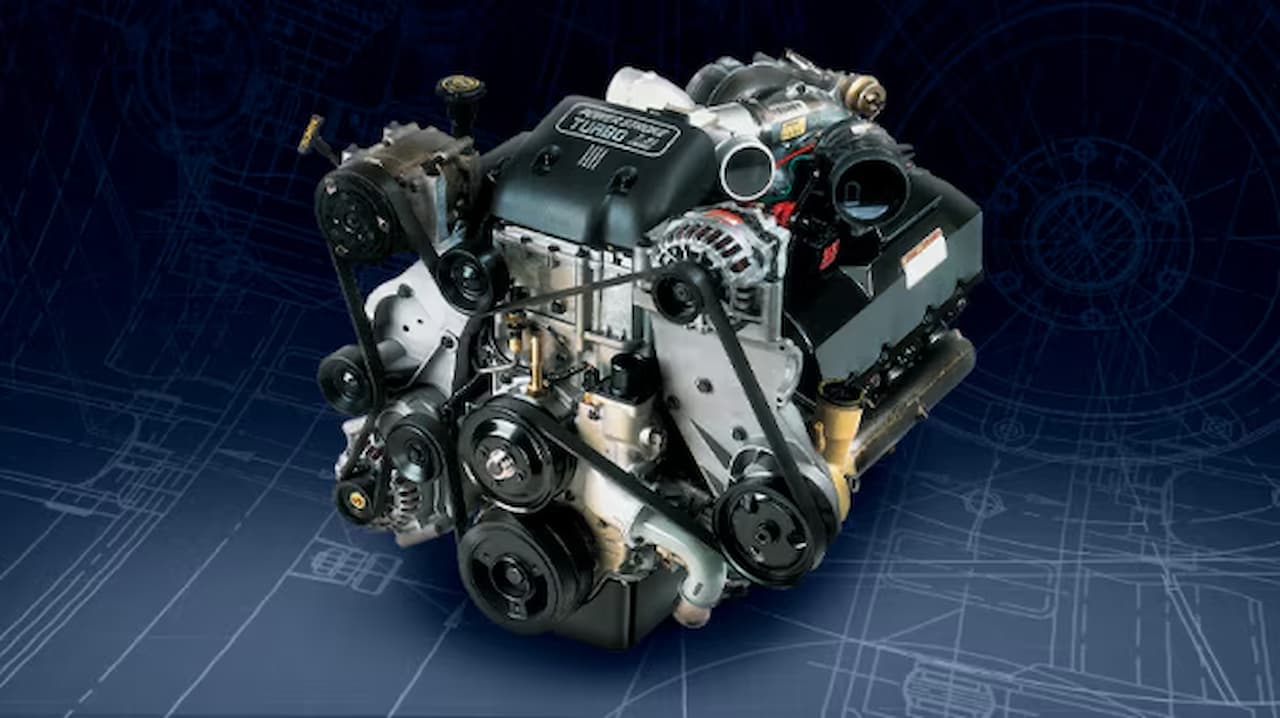 Ford 7.3L Power Stroke diesel engine showing turbocharger, alternator, pulleys, and various components against blue technical blueprint background
