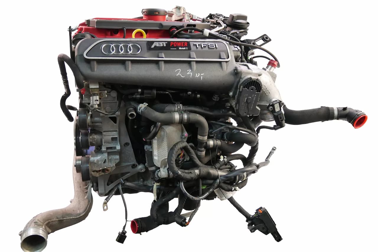 Audi 2.5 TFSI turbocharged engine assembly with black plastic cover, ABT tuning modifications, and extensive wiring harnesses attached