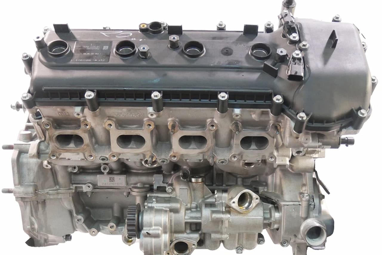 McLaren M840T twin-turbo V8 engine showing black valve cover, aluminum cylinder head, intake ports, and precision-machined components