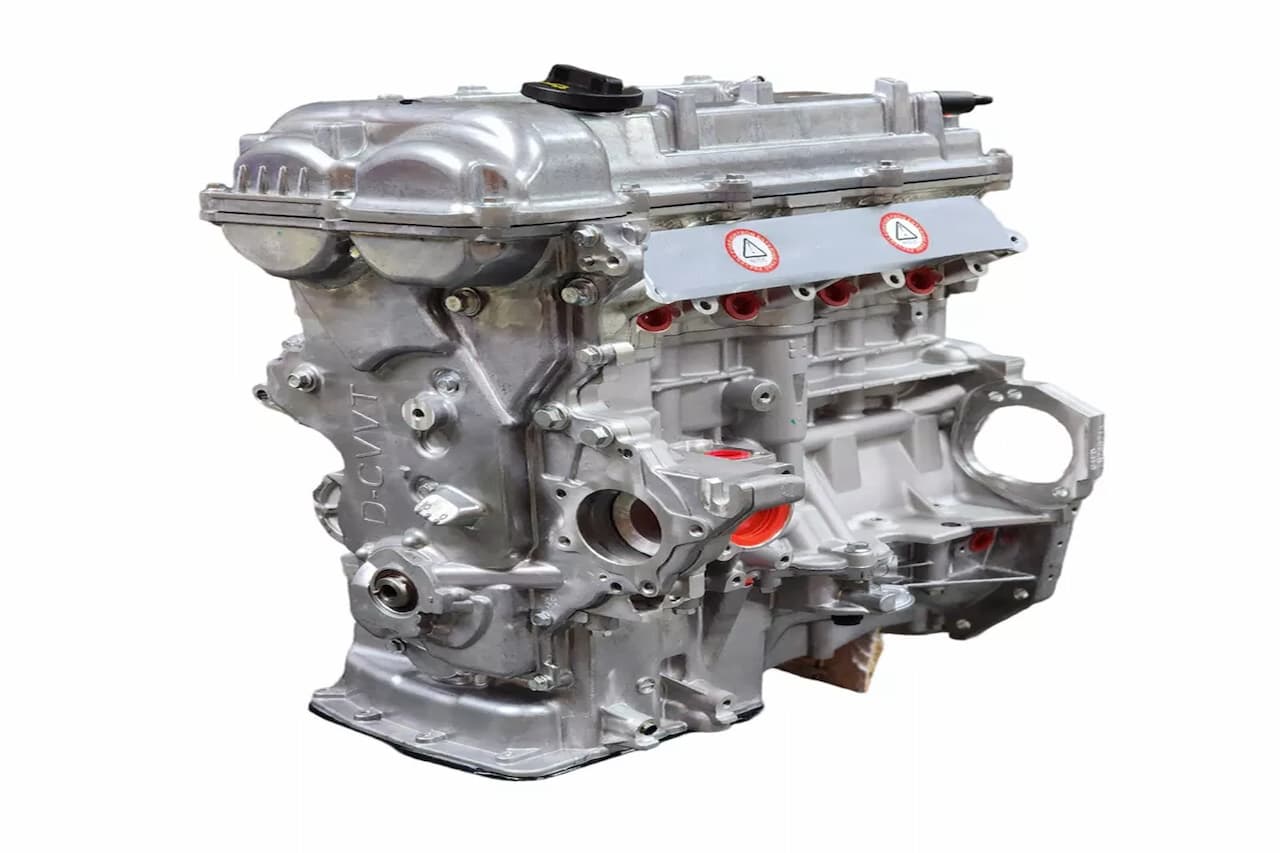 Hyundai 1.6L Gamma GDI engine assembly with intake manifold, aluminum block, red protective caps, and warning stickers installed