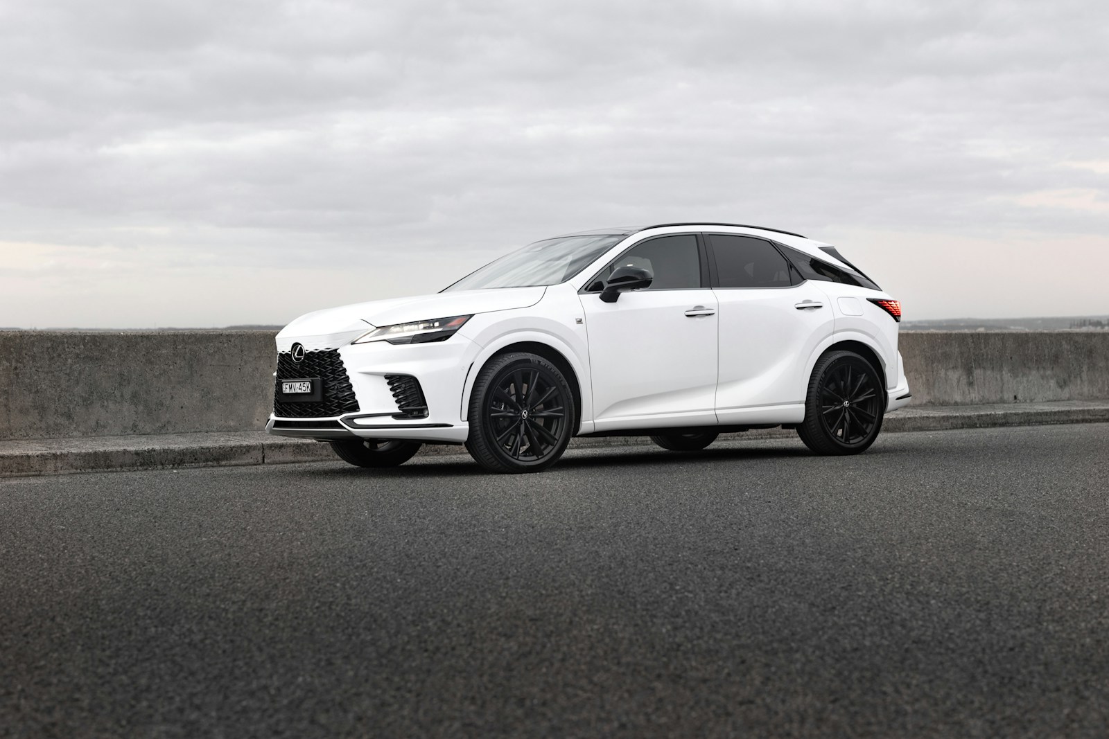 A white lexus suv is parked on the road.