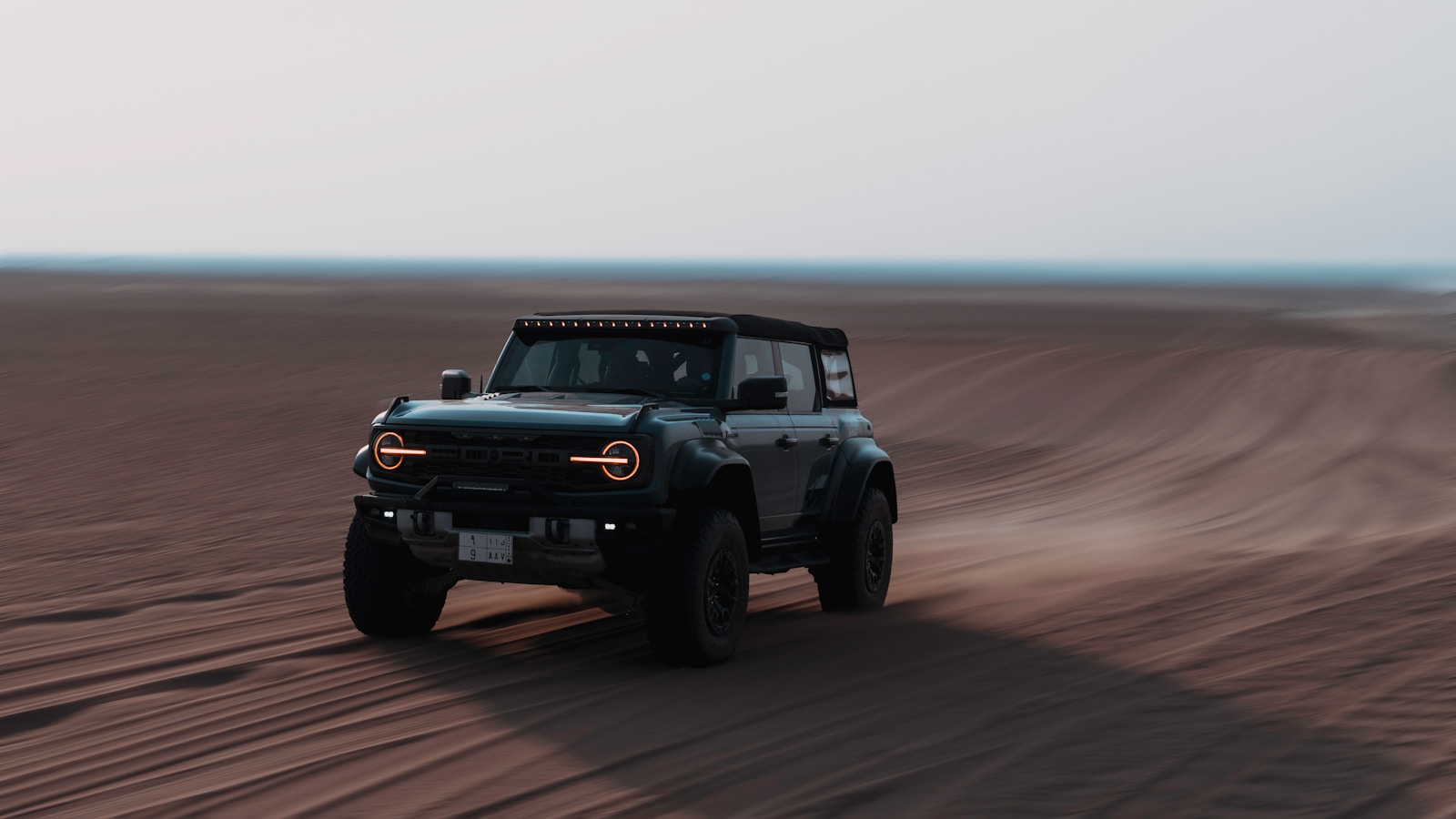 A jeep driving through the desert on a clear day