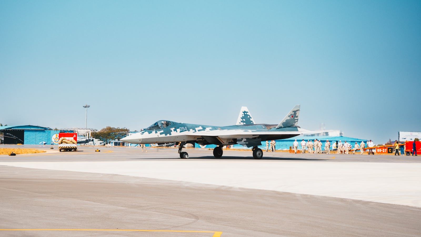 A Sukhoi Su-57 fighter jet stationed on a military airfield runway.