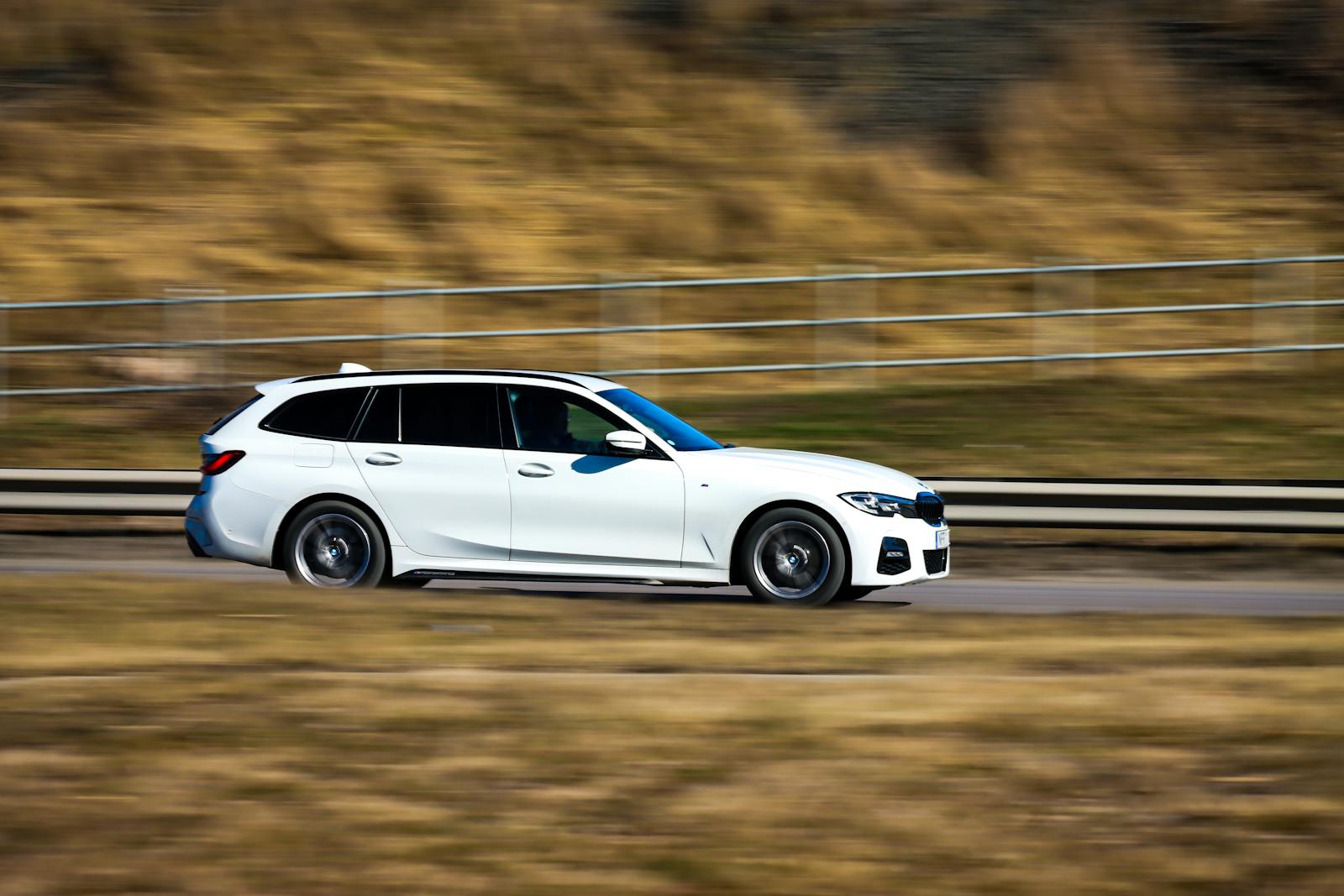 A sleek white car in motion on a rural road in Jönköping, Sweden.