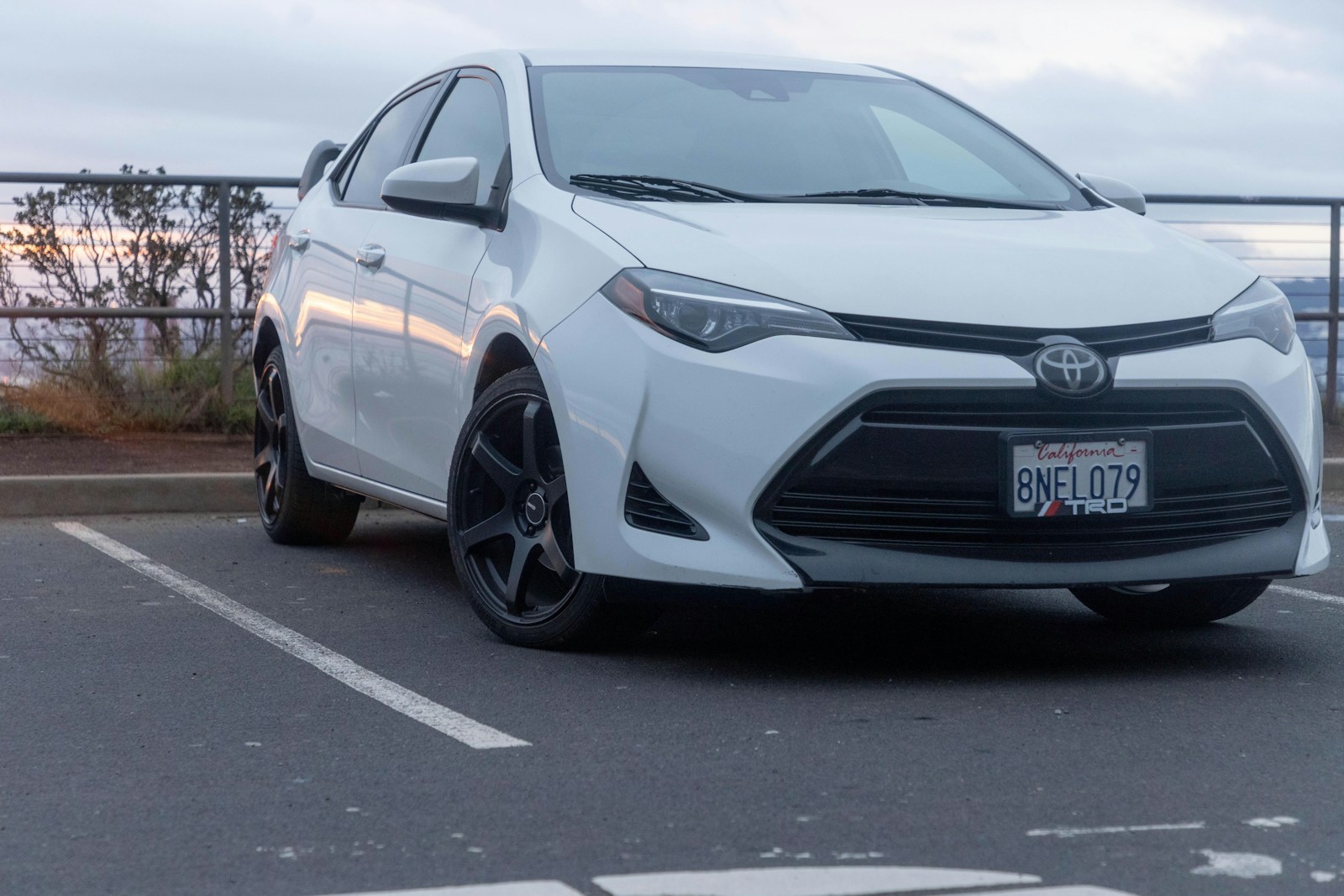 A white car is parked in a parking lot