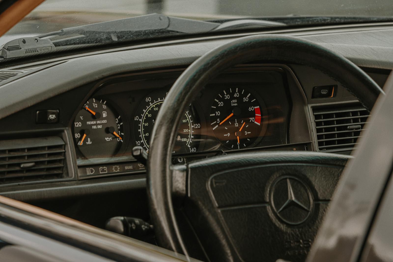 Interior view of a classic Mercedes-Benz dashboard showing gauges and steering wheel.