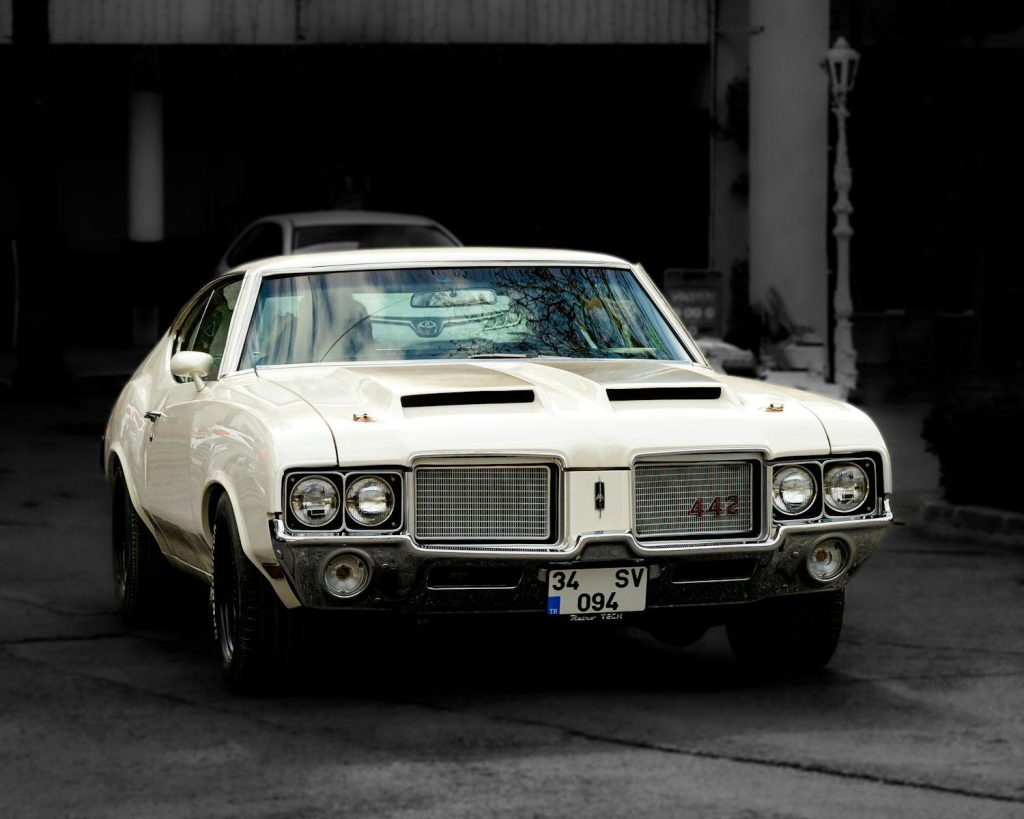 Front view of a classic Oldsmobile 442 muscle car in an urban setting.