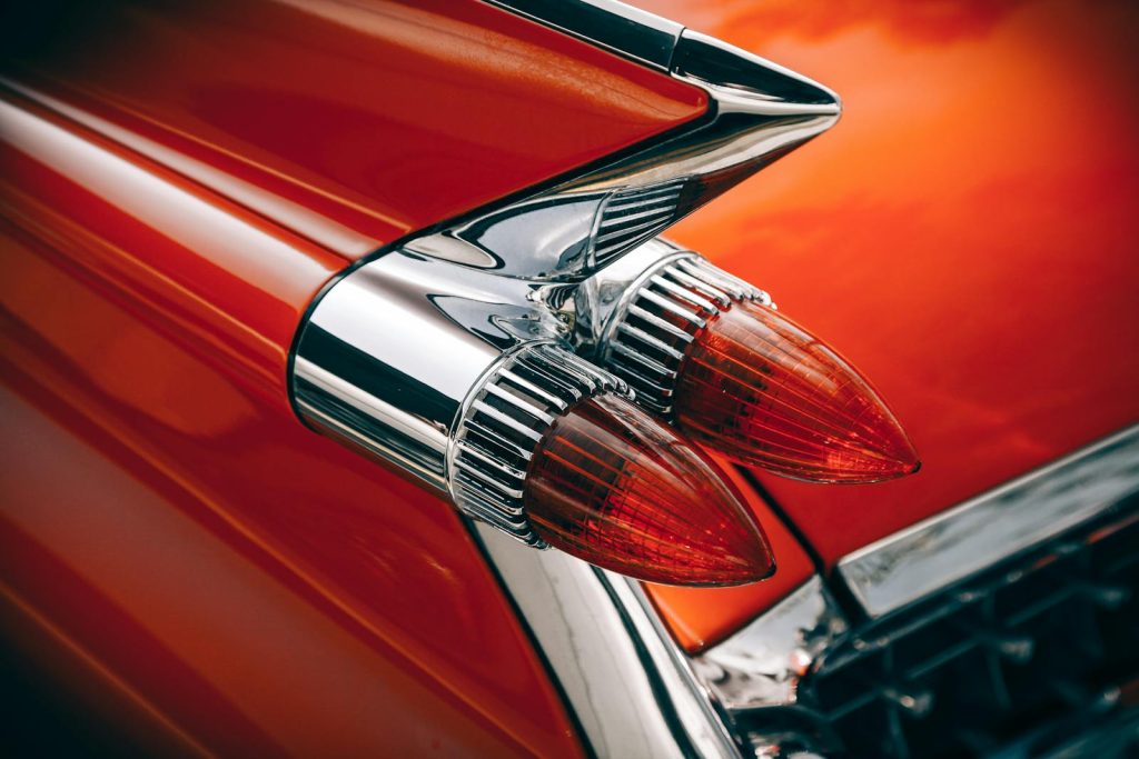 Close-up of retro car tail lights with chrome and vibrant colors.