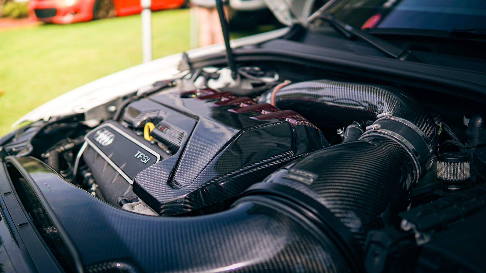 Detailed view of an Audi engine with carbon fiber enhancements, showcasing automotive technology.
