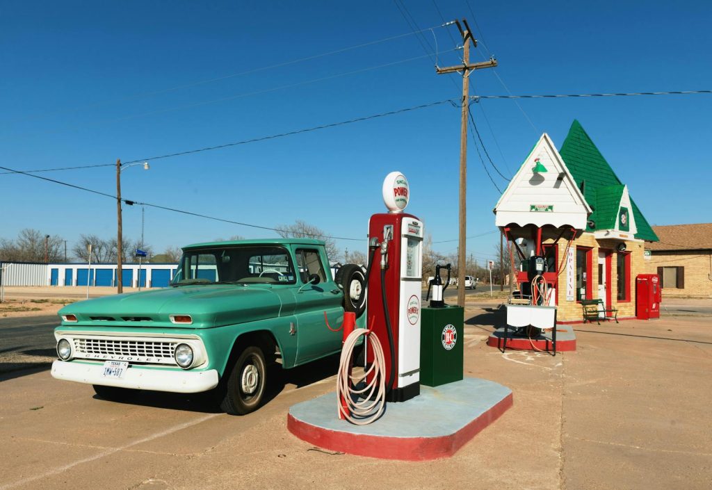 A retro gas station with a vintage truck and bright blue skies, ideal for travel nostalgia.