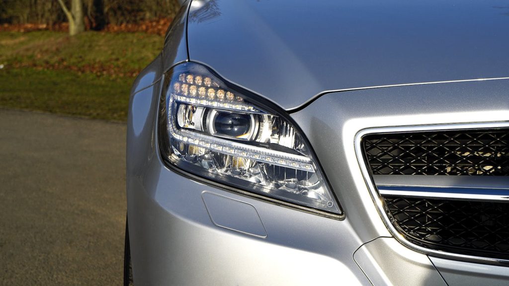 High-quality image of a silver luxury car with a focus on the headlight.