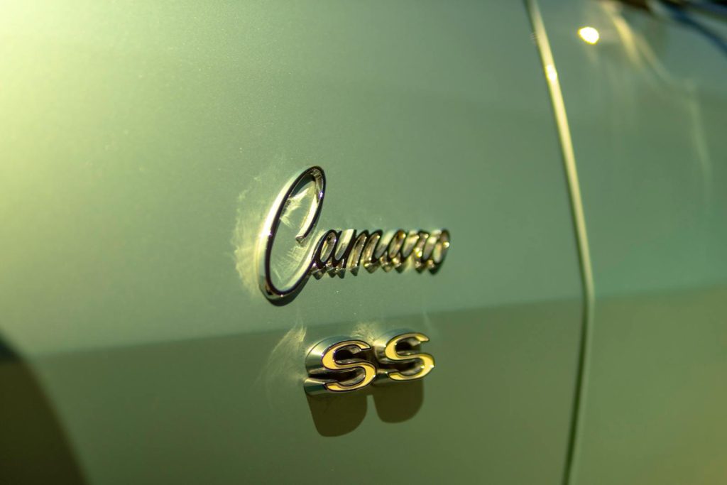 A close-up of the Chevrolet Camaro SS emblem with a shiny, vintage car finish.