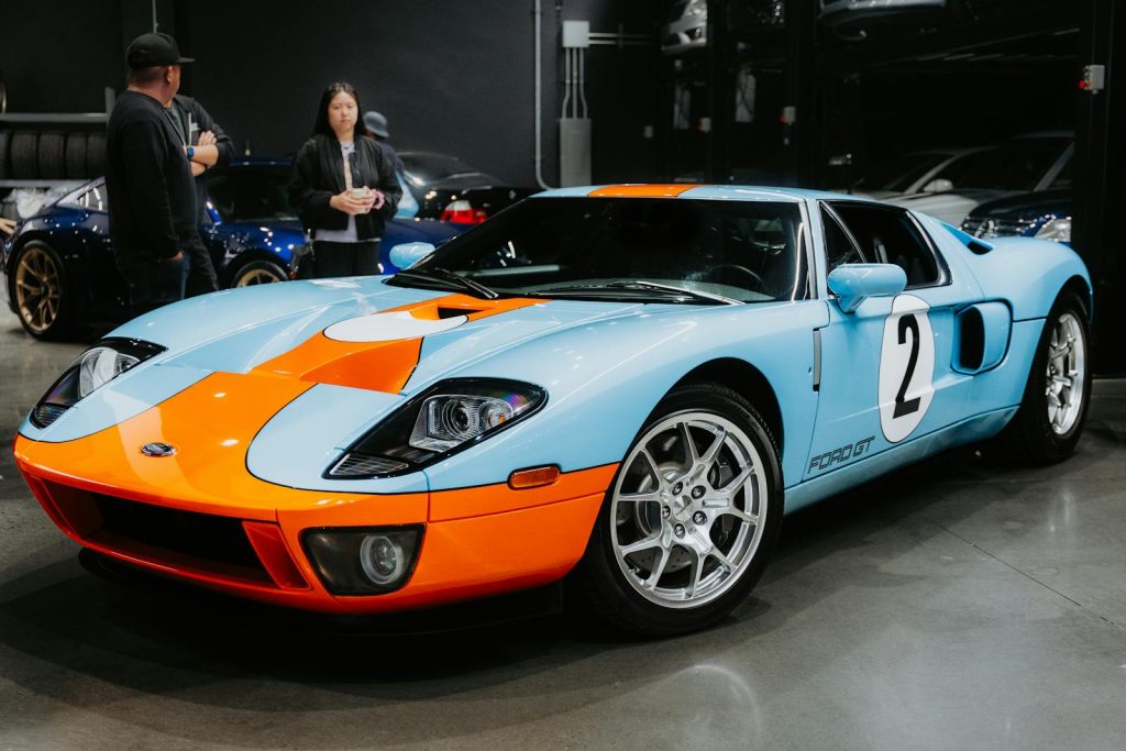 Classic Ford GT40 car with Gulf livery showcased indoors. Perfect for automobile enthusiasts and vintage car fans.
