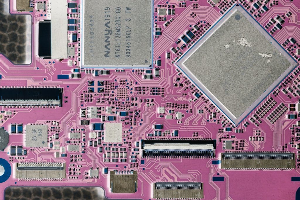Close-up of a pink circuit board with electronic components.