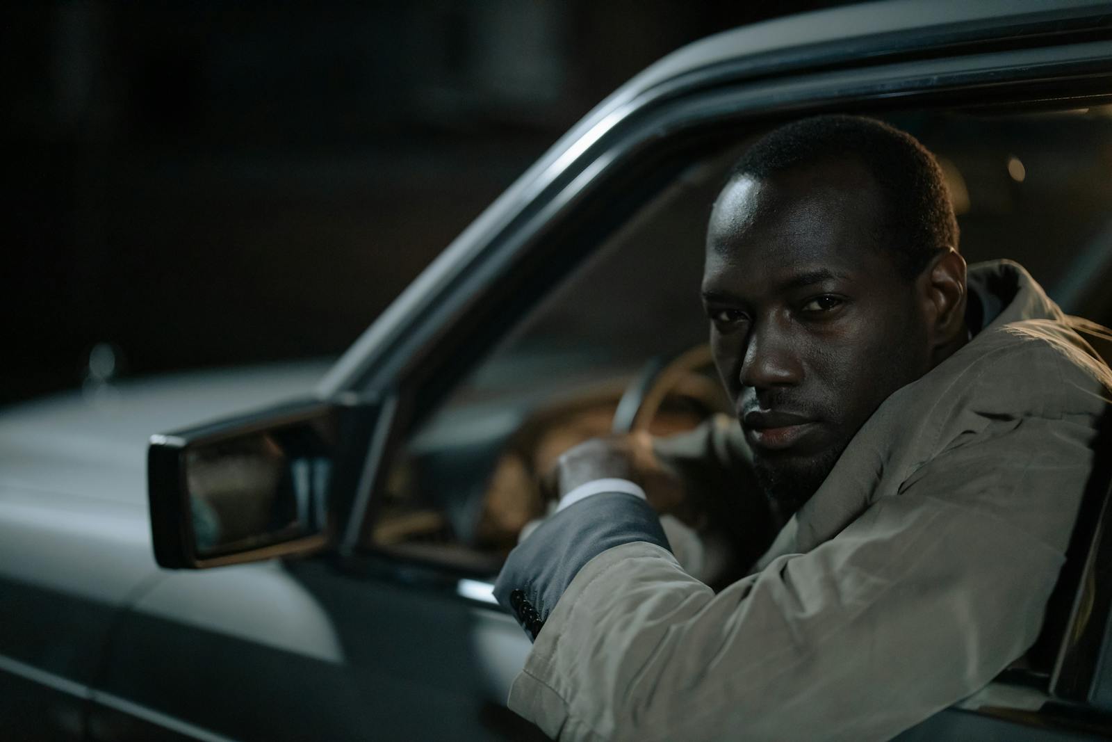 Portrait of a man driving a car at night, showing focus and contemplation.