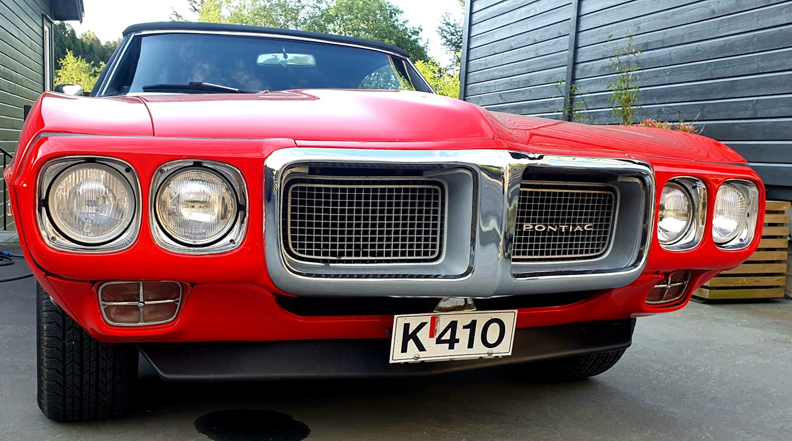 a red car parked in a driveway next to a building