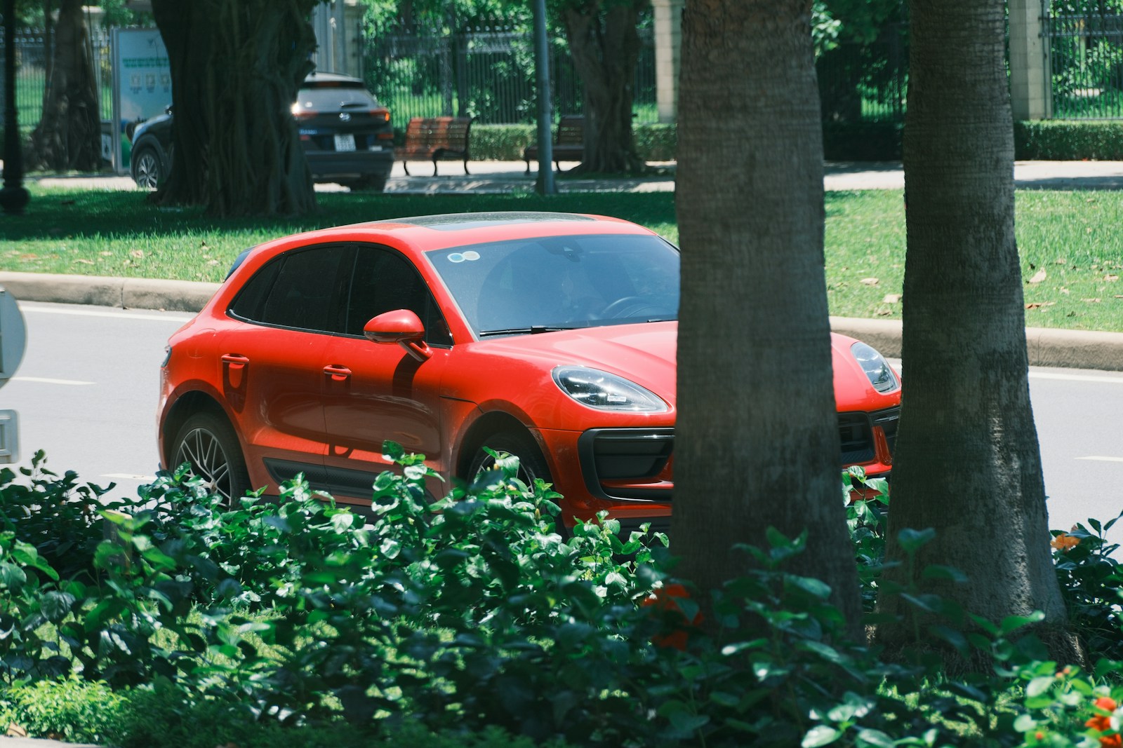 A red porsche suv is parked on the road.