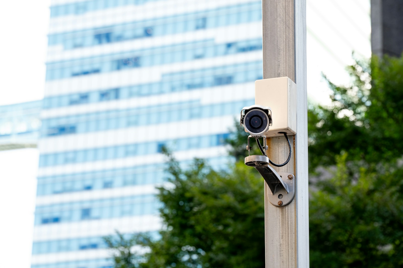 Security camera mounted on pole with building background