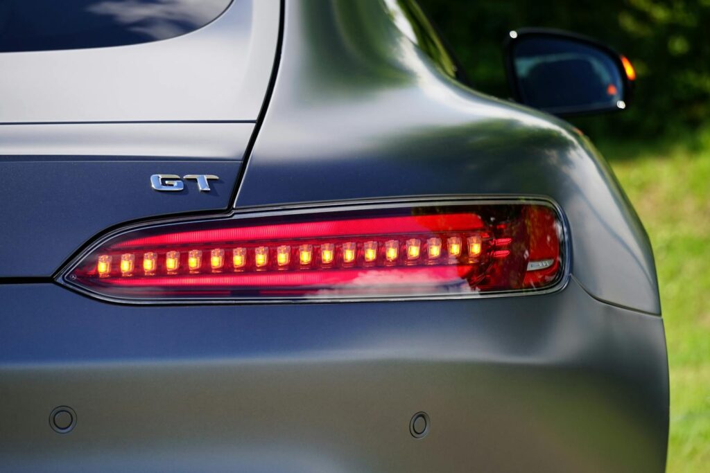 Close-up shot of a GT car tail light highlighting its sleek design and red LED lights.