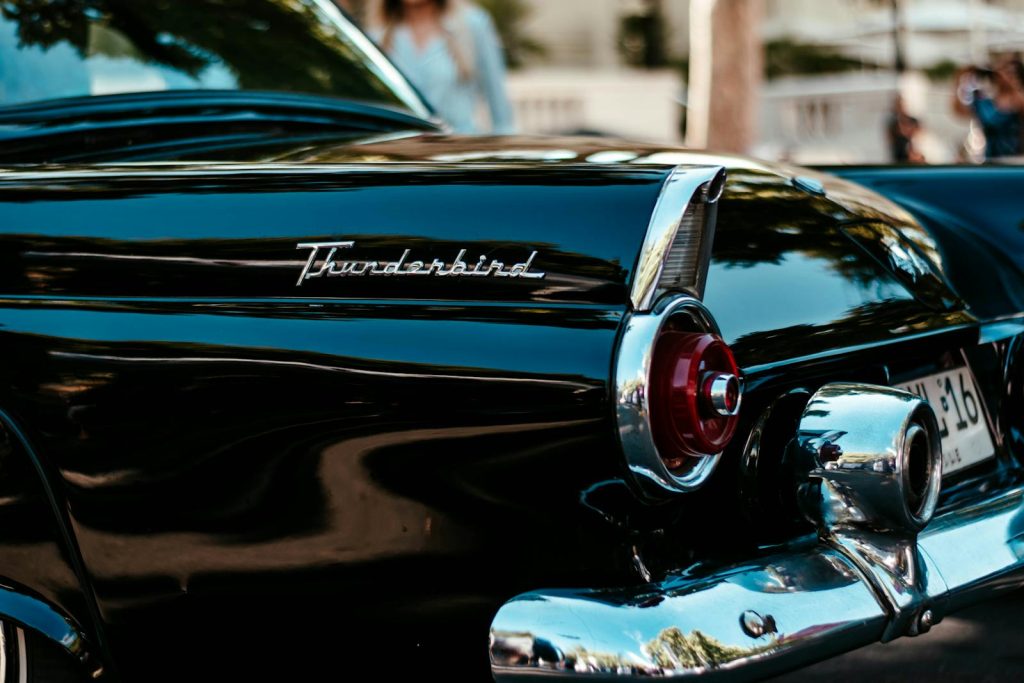 Close-up of a classic black Thunderbird car showing its sleek design and vintage charm.