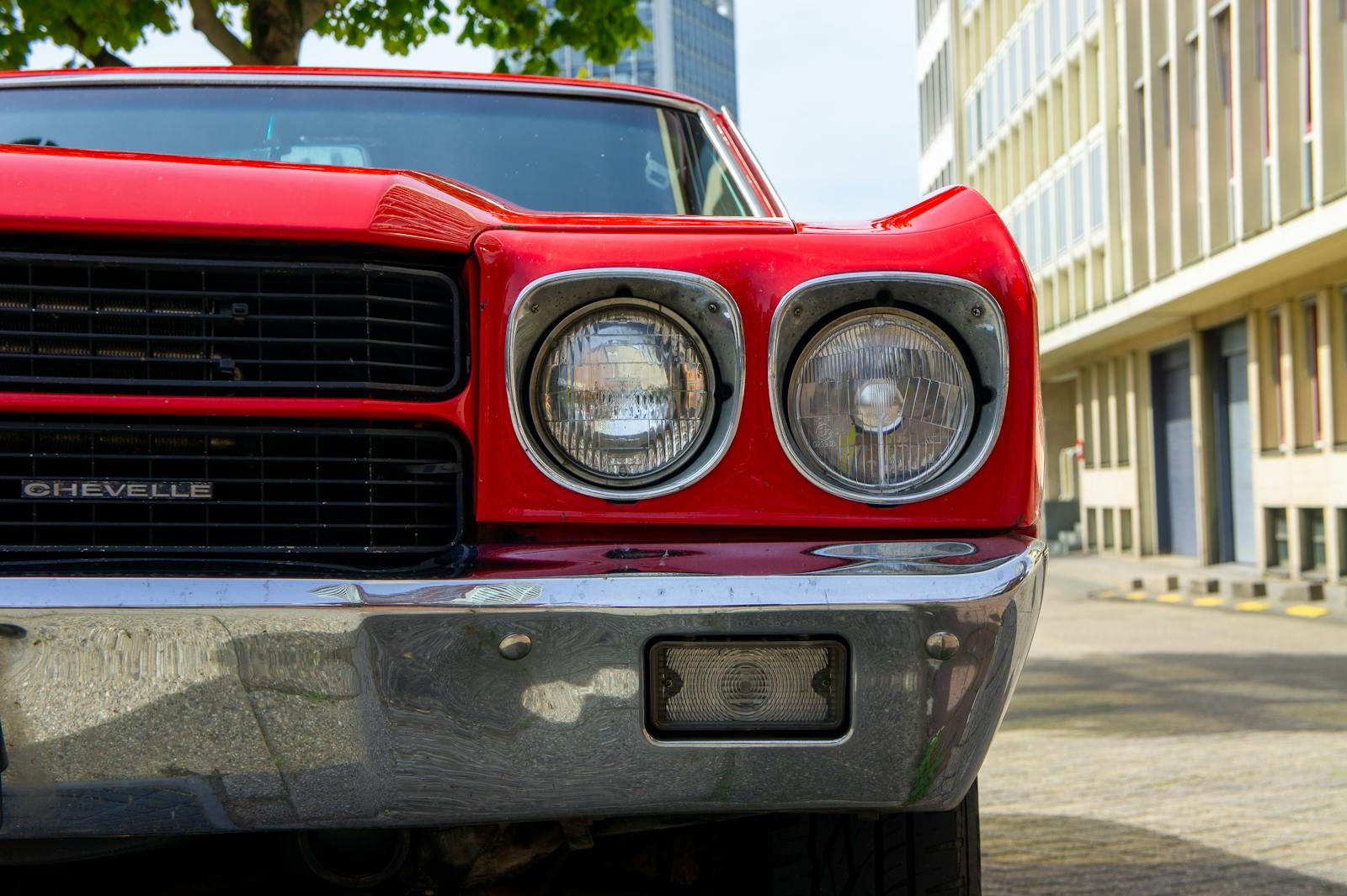 Detailed shot of a vintage red Chevrolet Chevelle on a city street in Rotterdam, Netherlands.