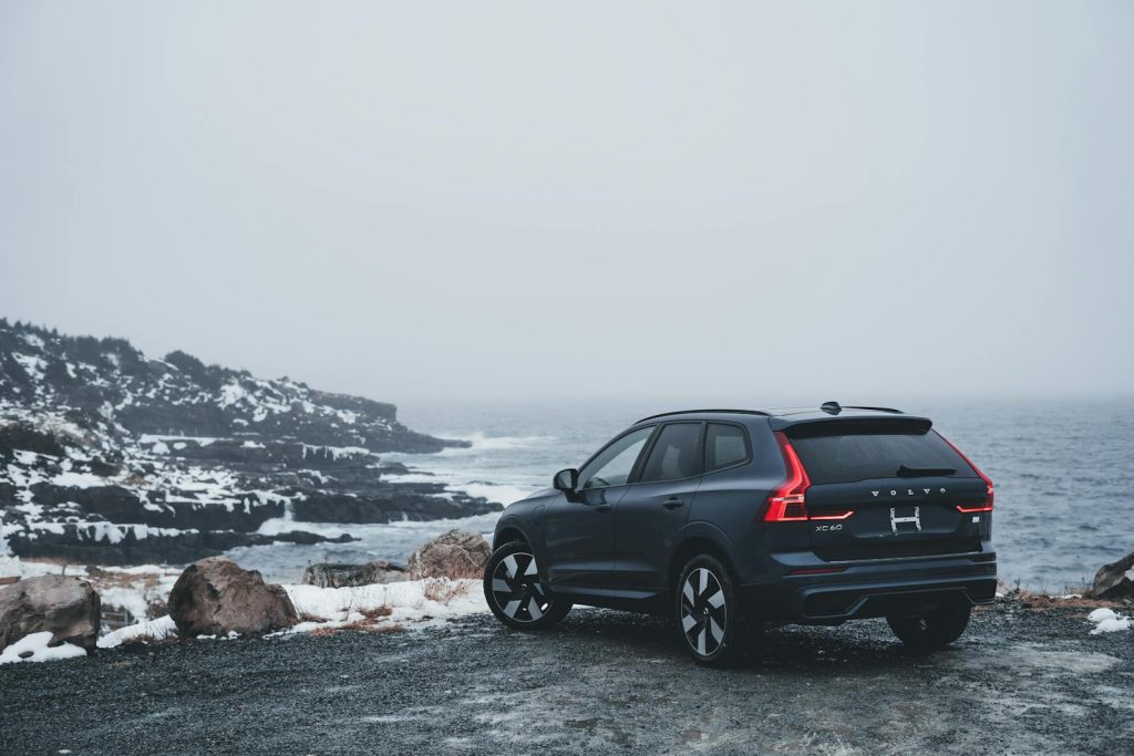 A Volvo XC60 depicted against a snowy coastal winter backdrop, highlighting adventure.