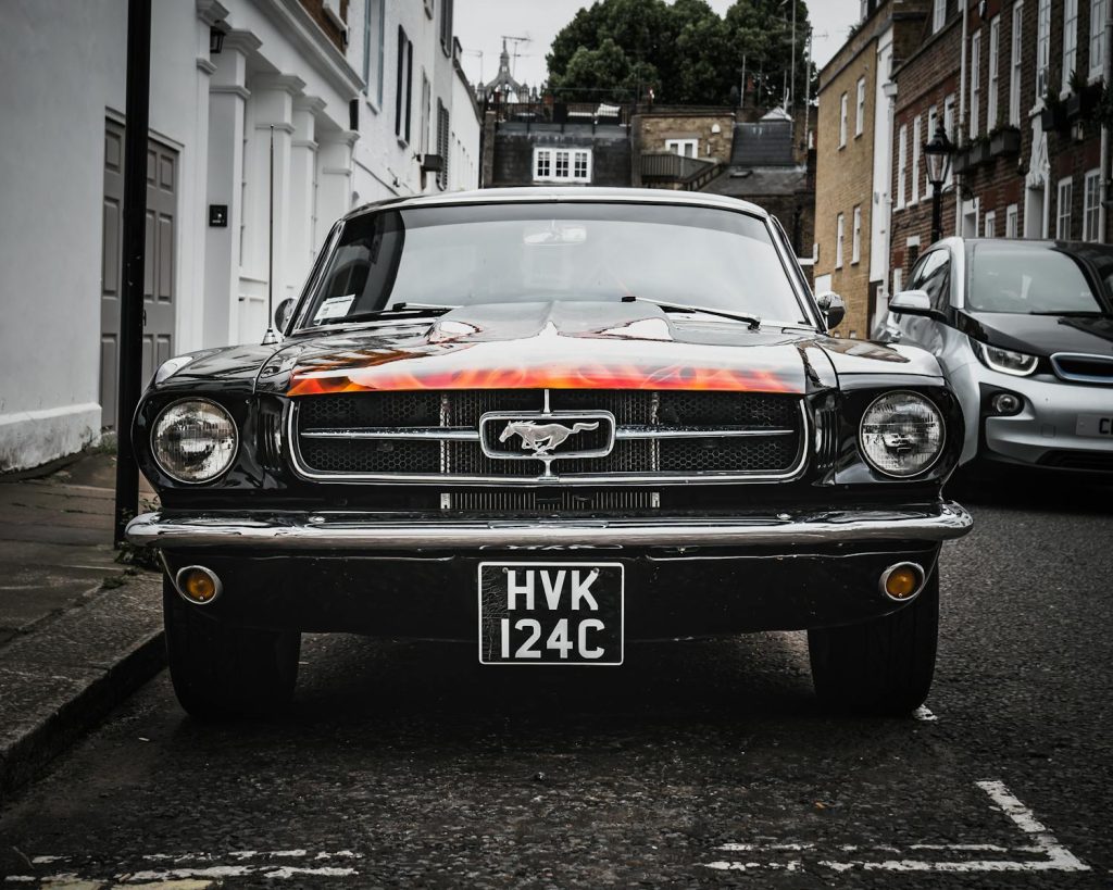 Front view of a vintage Ford Mustang parked on a London street, showcasing iconic design.