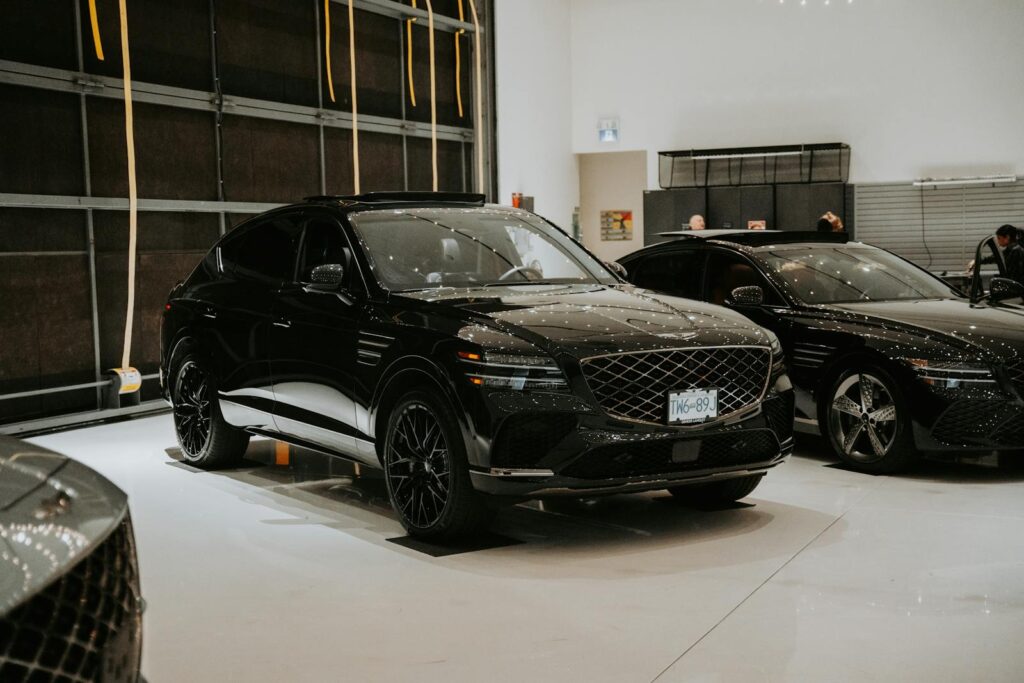 Luxury black SUVs displayed in an indoor car showroom with elegant lighting.