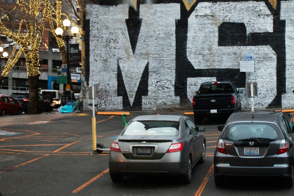 Cars are parked in a city parking lot.
