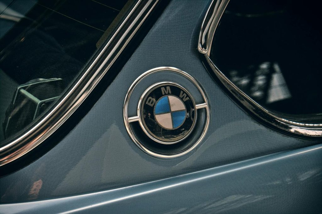 Close-up shot of a vintage BMW logo on a classic car. Iconic automotive detail.