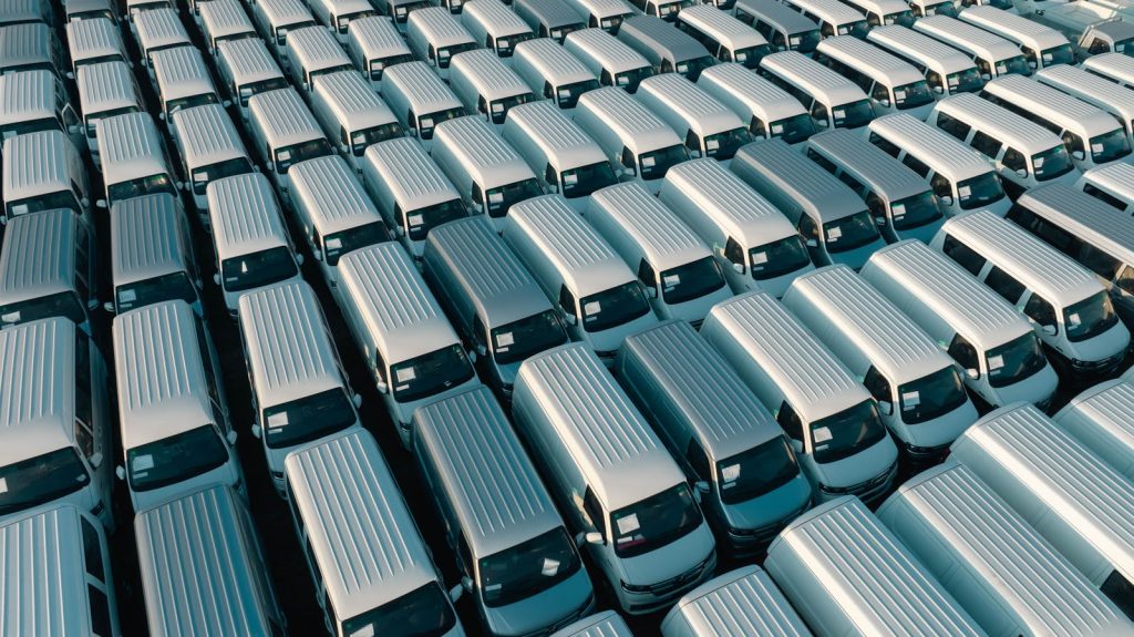 An aerial shot of a large fleet of white vans parked in rows under the early morning light in Libya.