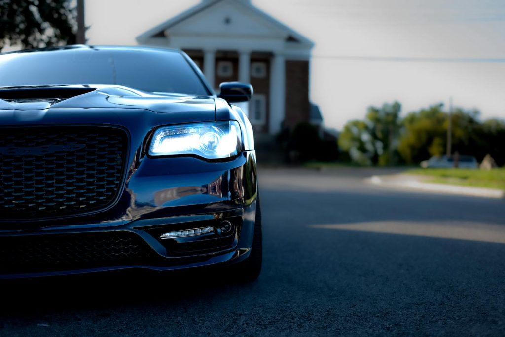 Elegant blue car with LED lights showcased on a clear day in an urban environment.